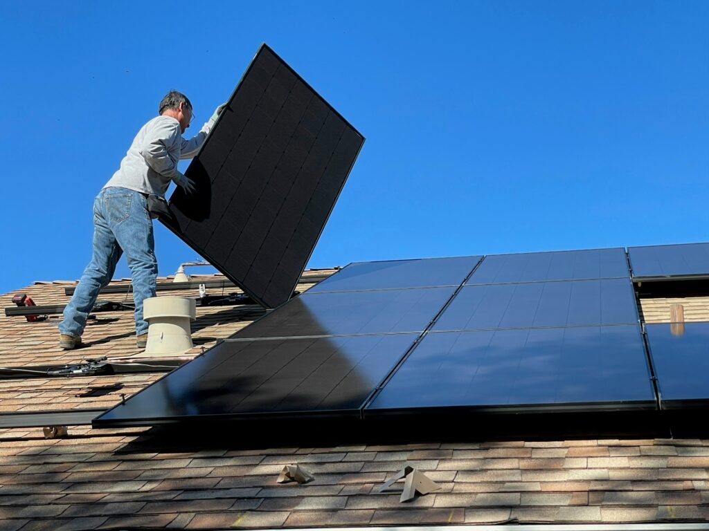Technician installing rooftop solar panels on a residential home in Kerala, showcasing professional installation standards followed by the best solar company in Kerala.