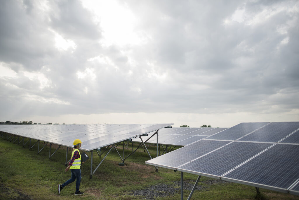 Technician inspecting a solar power plant installation using the best solar panels in Kerala for reliable and sustainable energy generation.