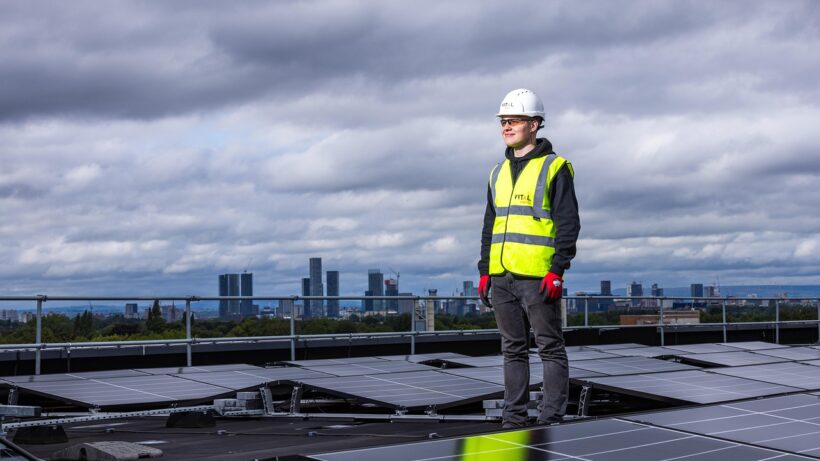 Technician inspecting rooftop solar panels installed by professional solar companies in Kerala for residential clean energy systems