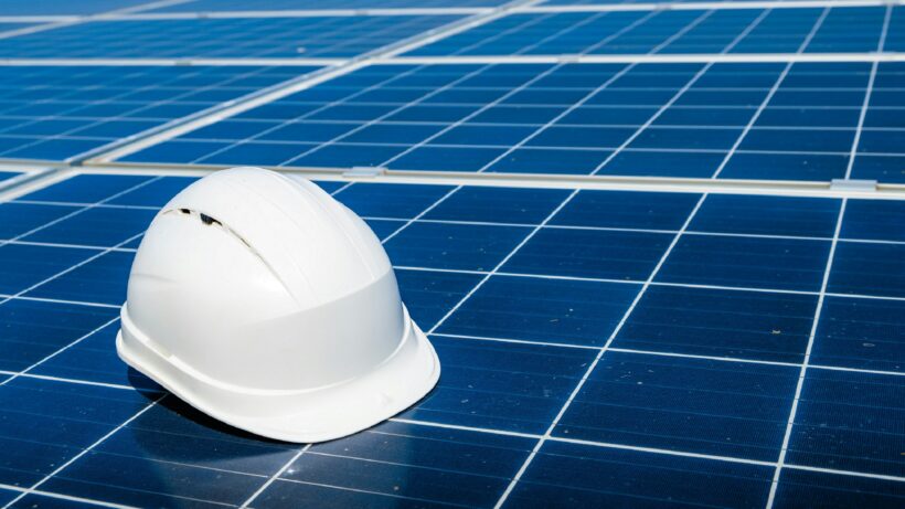 Rooftop solar panel installation equipment and safety helmet placed on solar panels, representing professional services by solar companies in Kerala for residential solar energy systems.