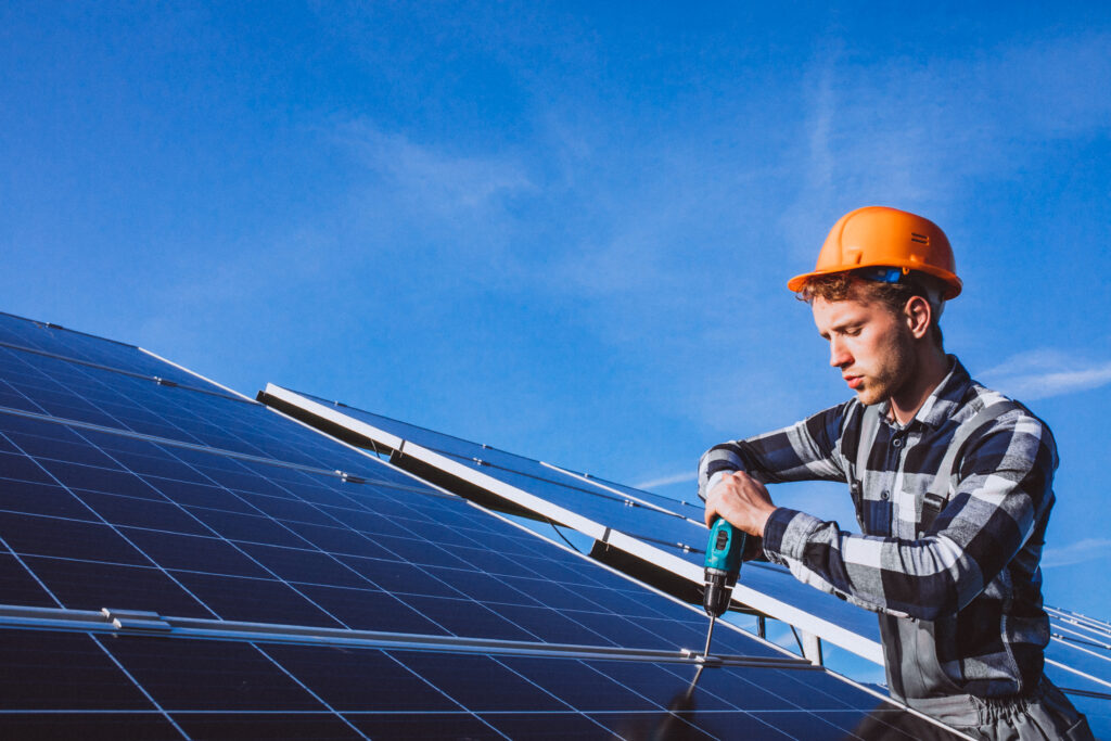 Technician installing solar panels on a rooftop, showcasing professional services by solar companies in Calicut for reliable and efficient solar energy solutions.